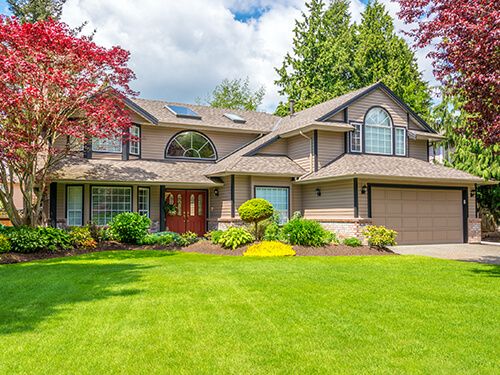 Luxury house with beautiful landscaping on a sunny day.